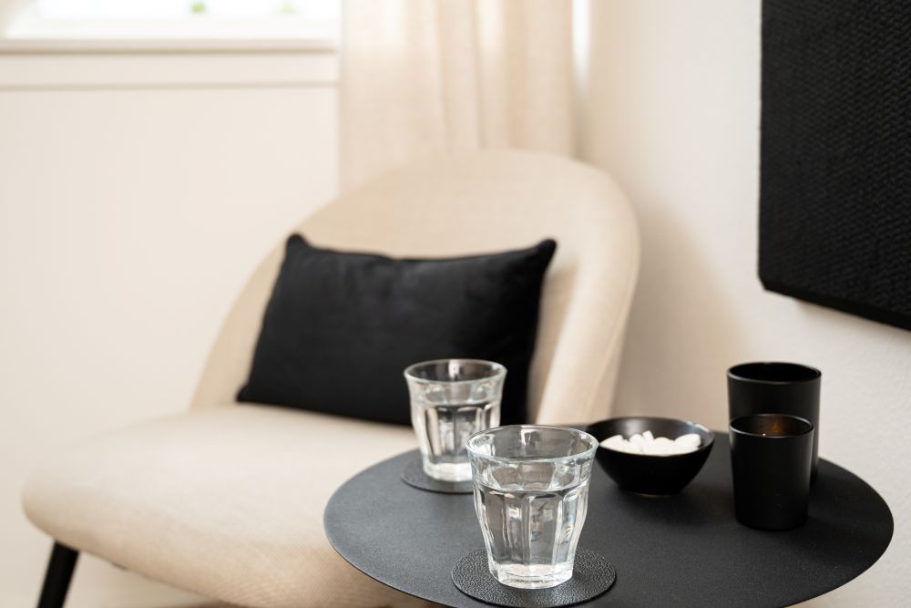 Comfortabele fauteuil met een glas water bij aankomst in het massage-atelier