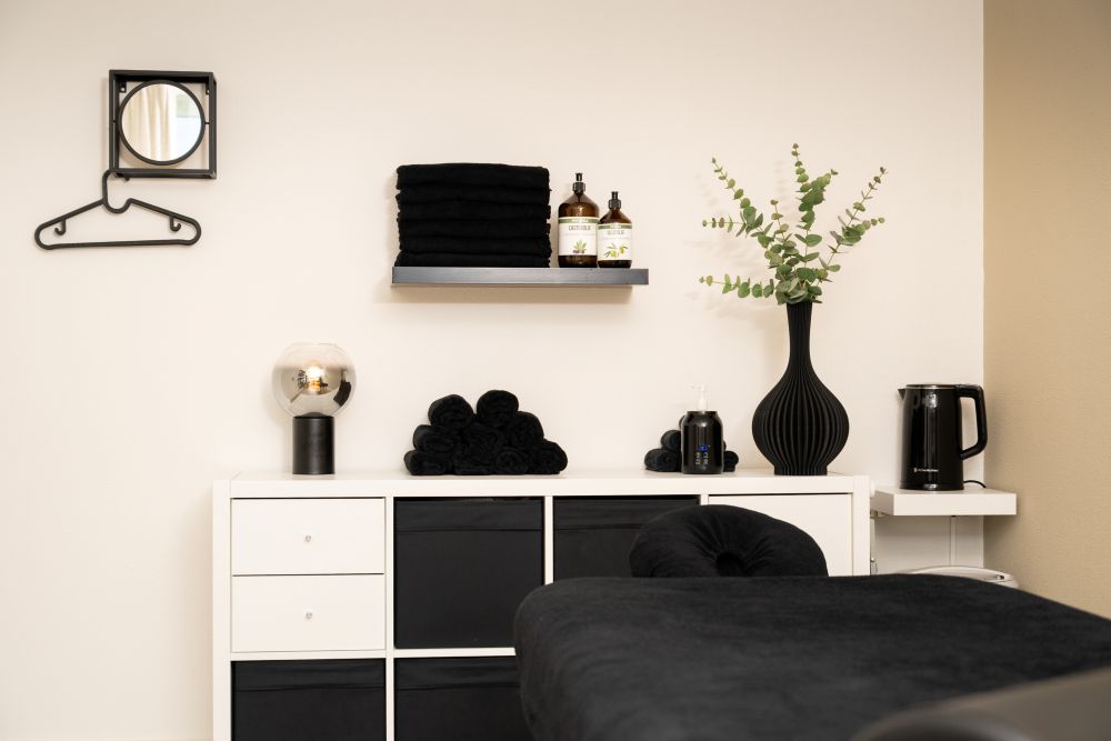 Massagekast met opgevouwen handdoeken, biologische massageoliën en eucalyptus