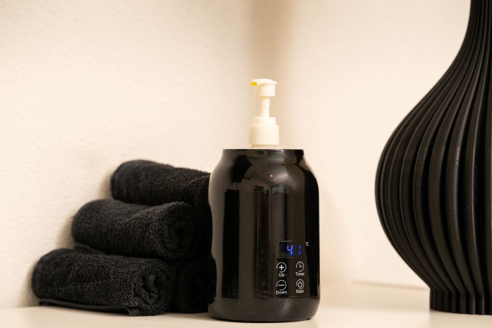 Professionele oliewarmer met opgerolde handdoeken voor een warme massage