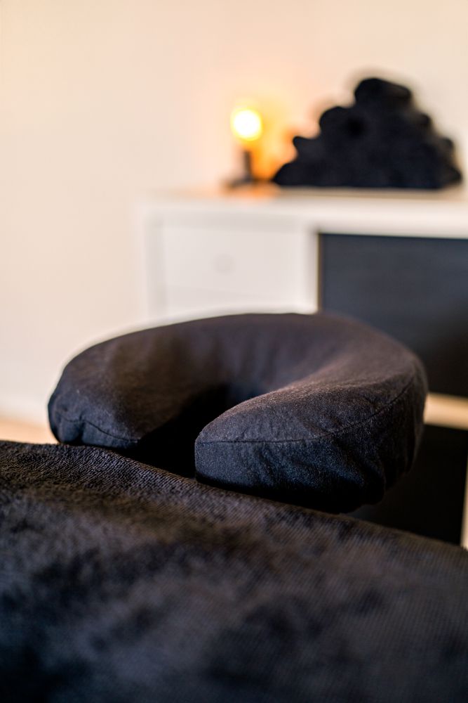 Zwart gezichtskussen op de massagetafel voor een comfortabele houding